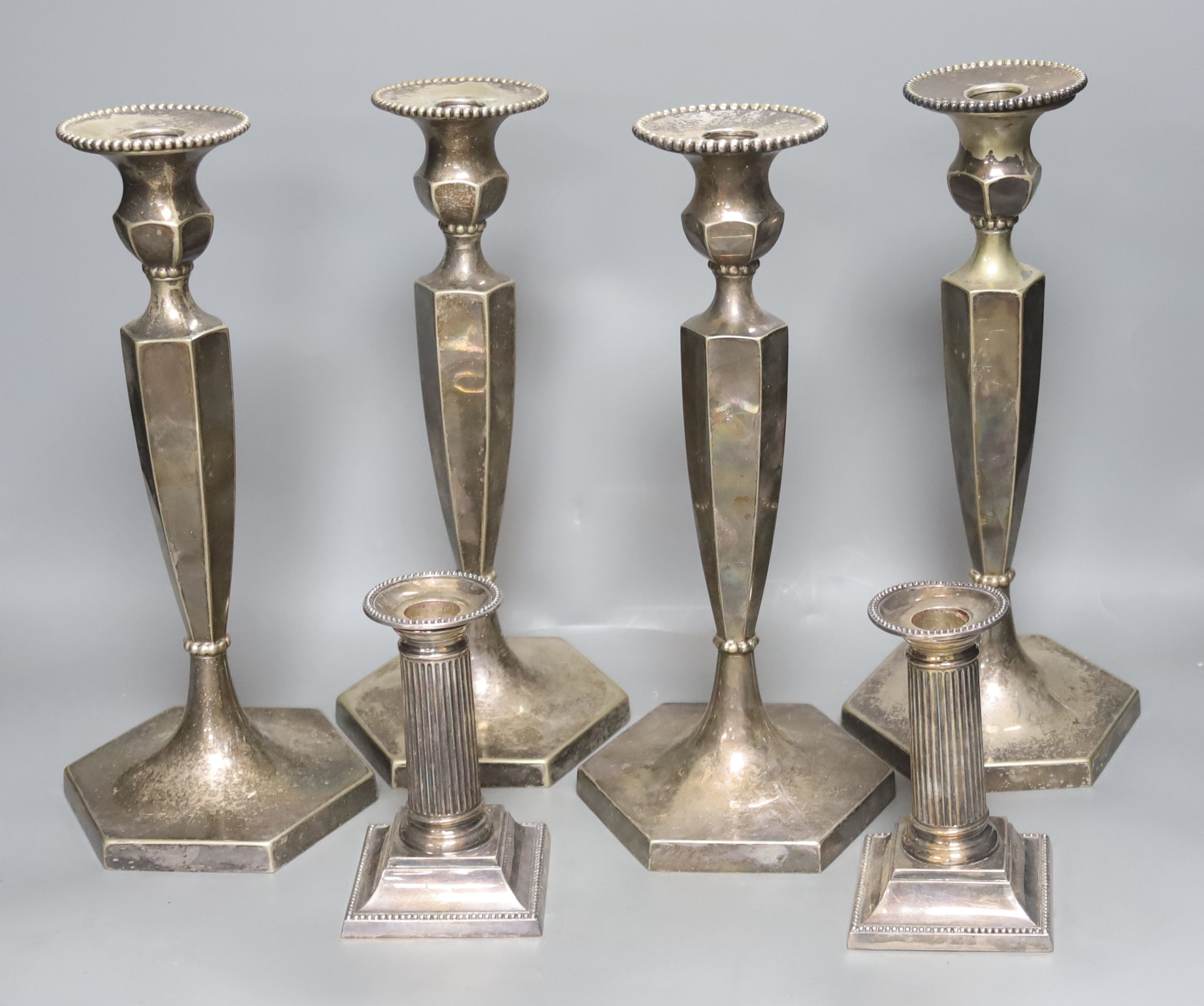 A set of 4 silver plated candlesticks and a pair of plated dwarf candlesticks